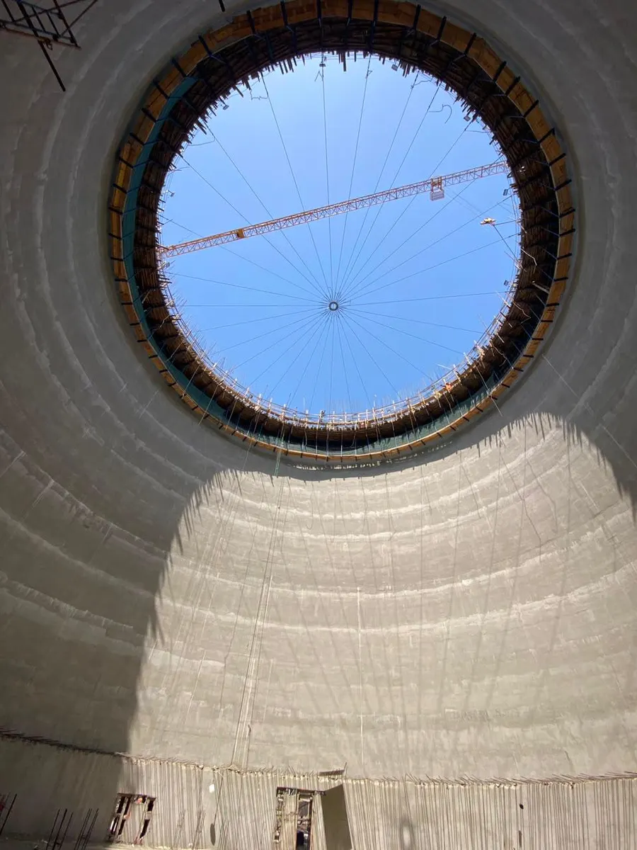 Interior of a silo looking up at the circular roof opening, with the radial roof formwork ties overhead