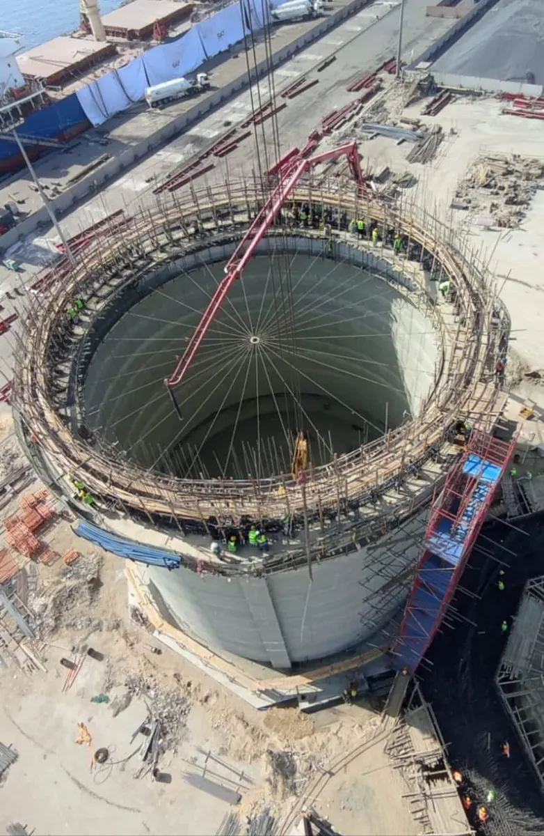 Aerial view of crews working around the silo top ring during the roof pour, with the radial roof formwork below