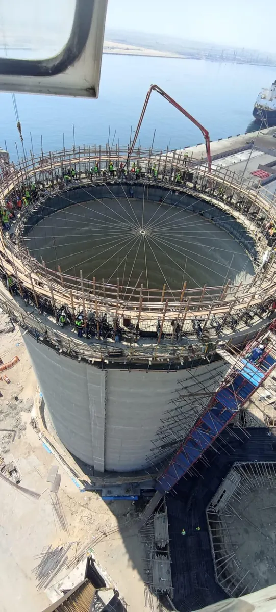 Silo top ring and radial roof formwork with the quay, a berthed vessel, and the sea behind