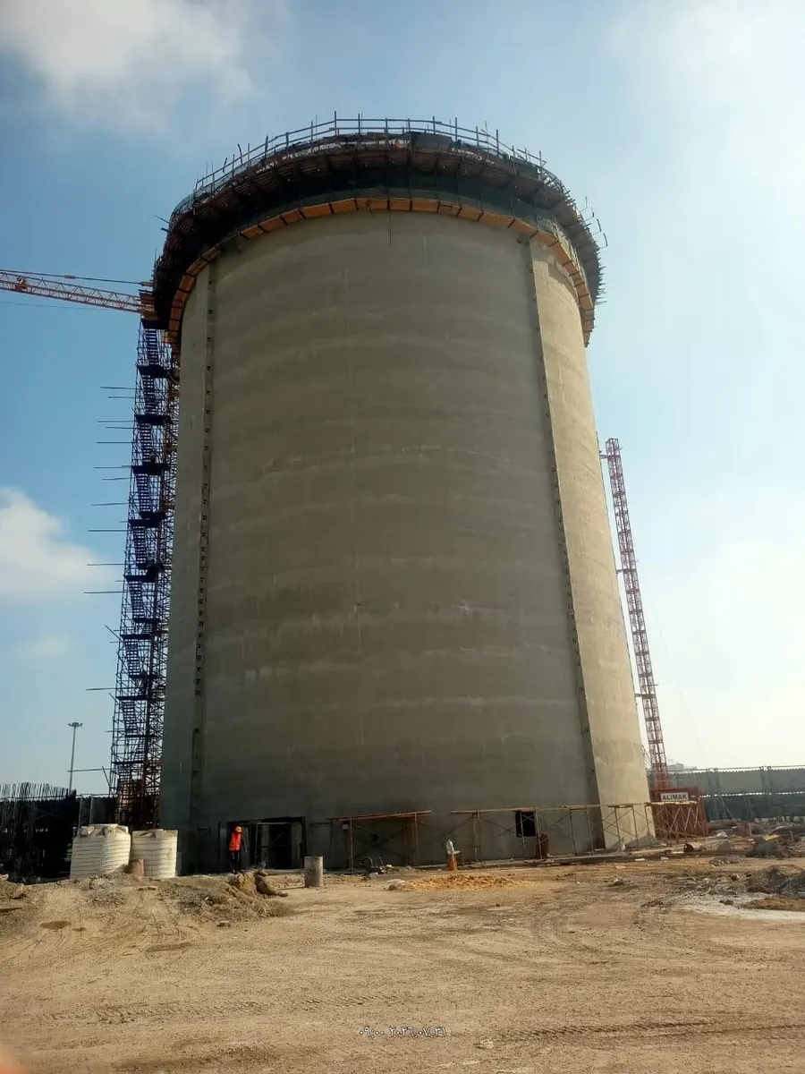 Silo wall at full height with the top ring formwork in place and climbing hoist masts on both sides