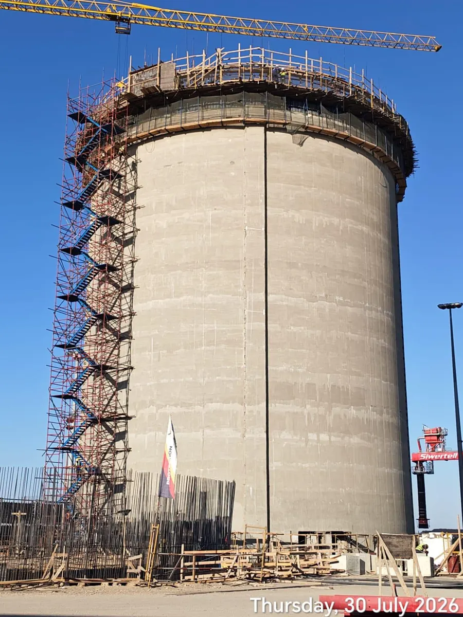 Silo wall at full height with a scaffold stair tower running the length of the shell