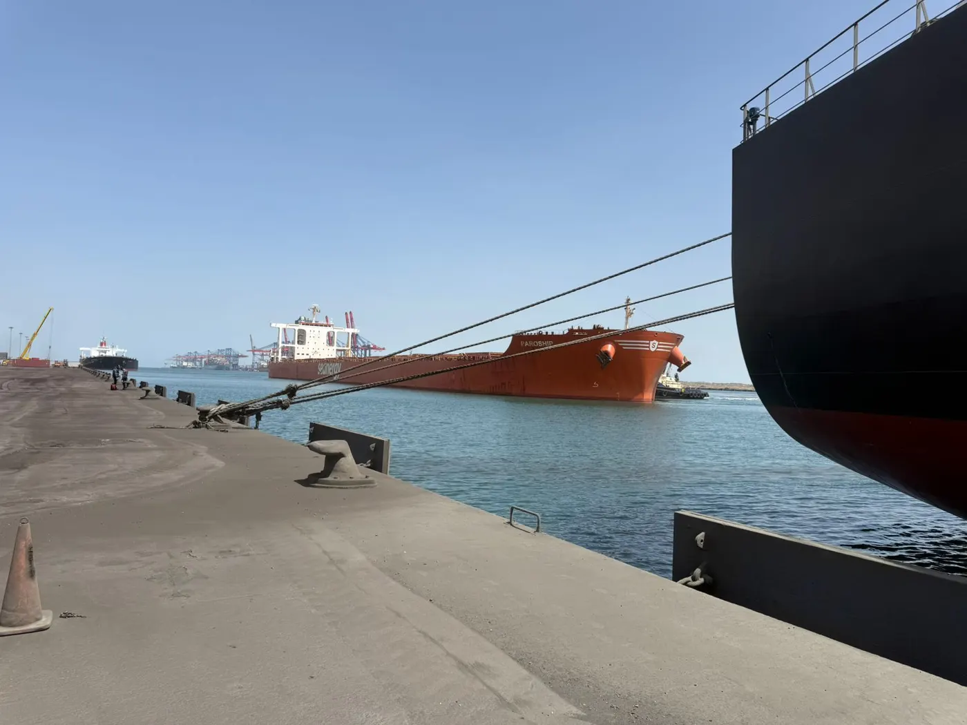 Tugboat assisting the MV PAROSHIP alongside another vessel at berth