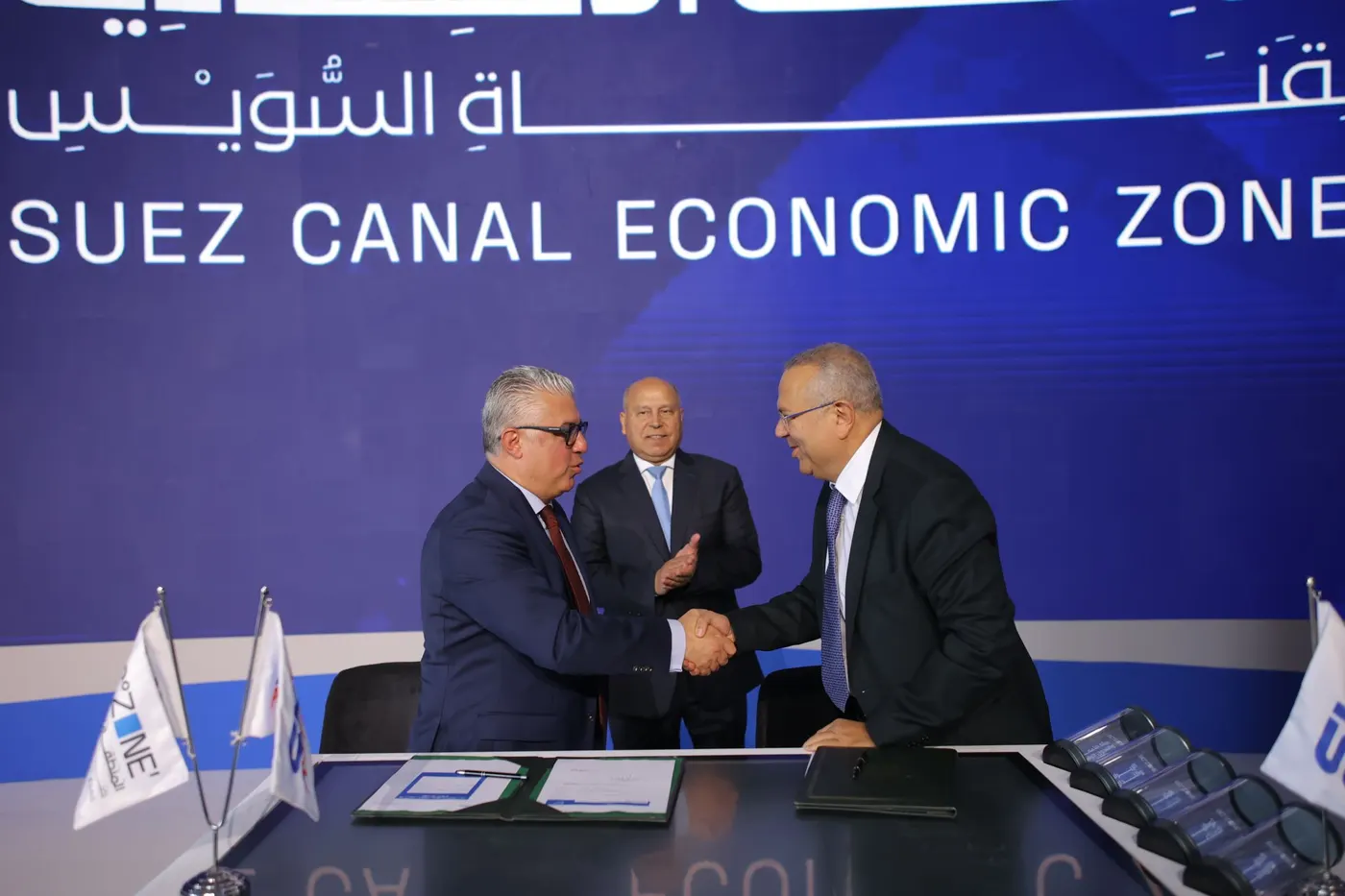 Sky Ports and Suez Canal Economic Zone representatives shaking hands after the signing