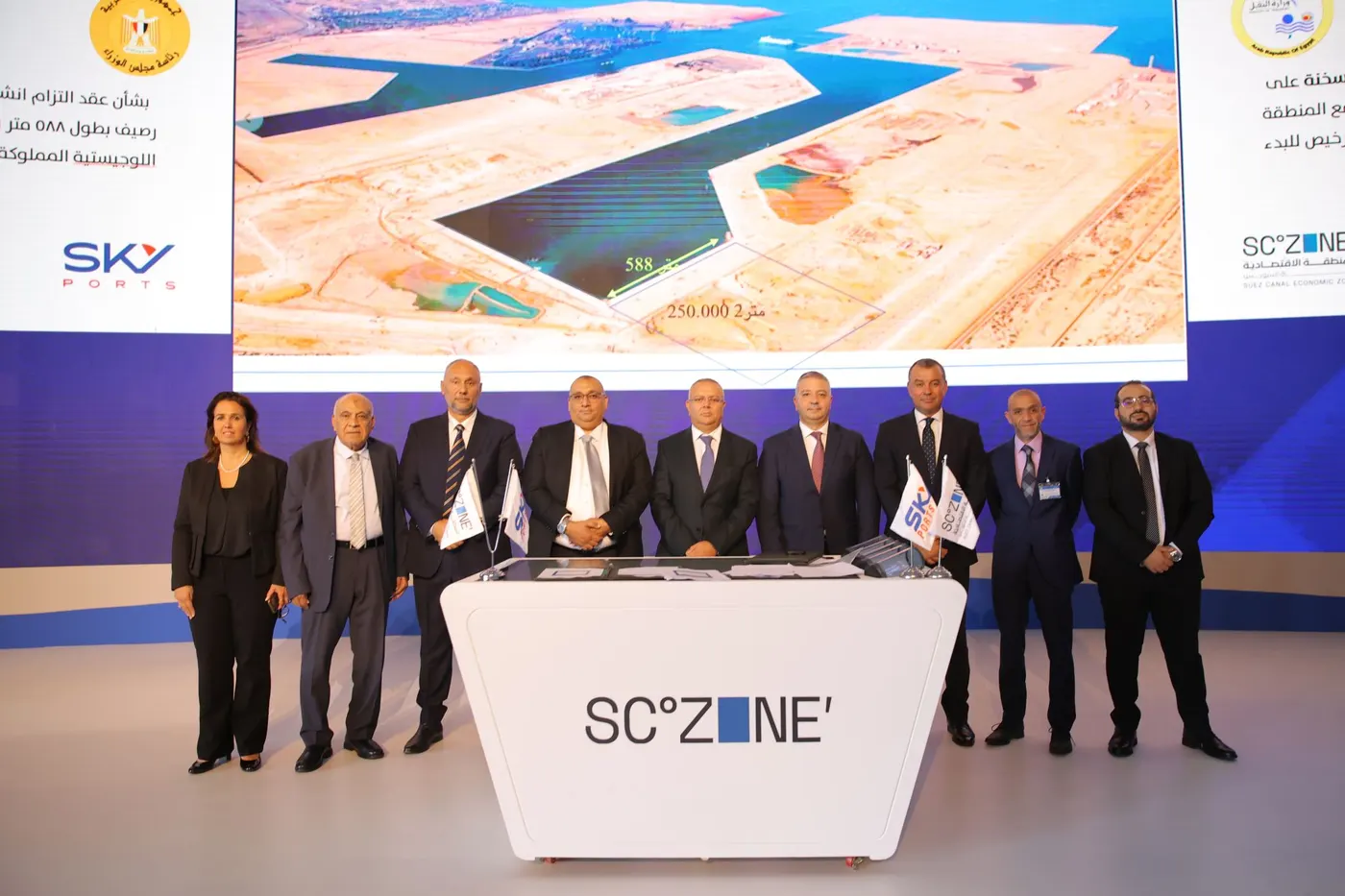 Officials on stage with the Ain Sokhna terminal plan displayed behind them