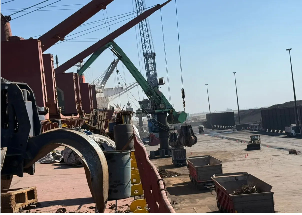 Organized quayside scrap discharge with cranes and trucks in a coordinated flow