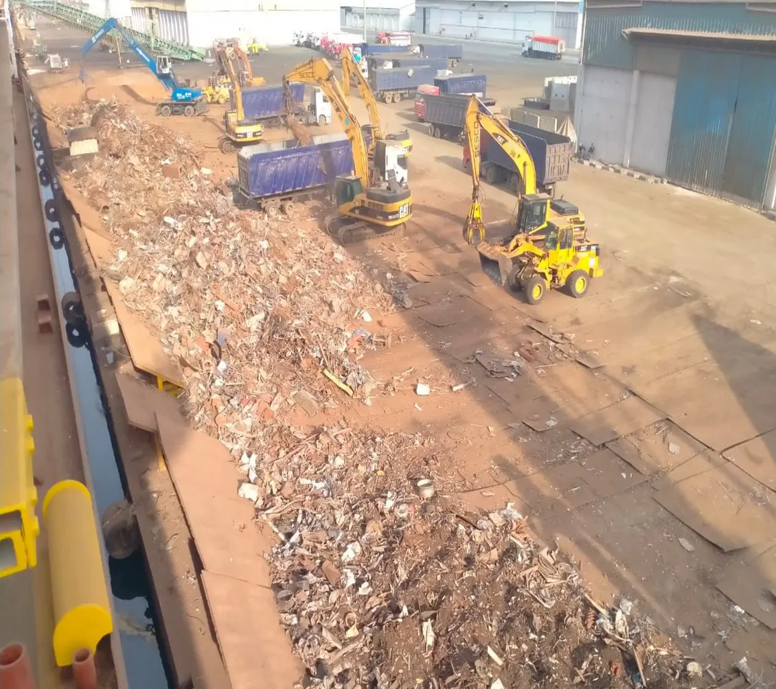 Scrap discharged into an open handling area and accumulated as an intermediate stockpile