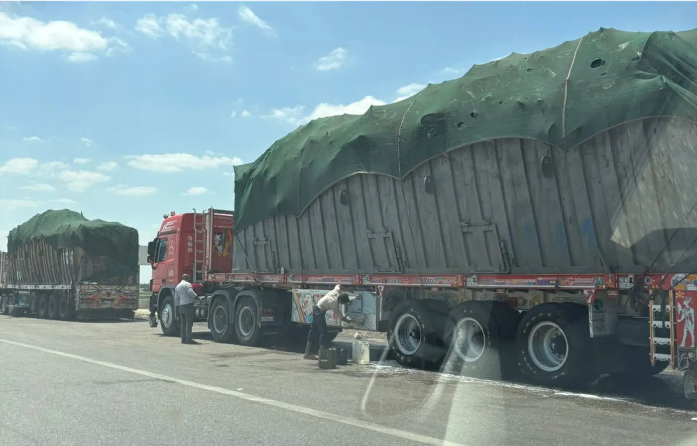 Trucks queued on the highway with cargo covering adjusted before dispatch